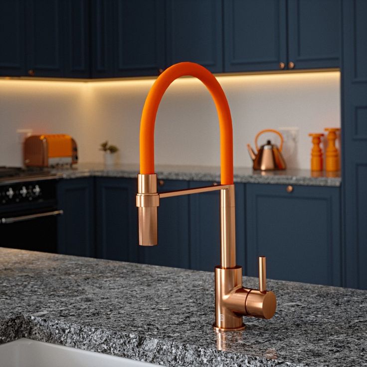 grey granite countertops, blue cabinetry, bronze fixings and appliances and bright orange kitchen tap.