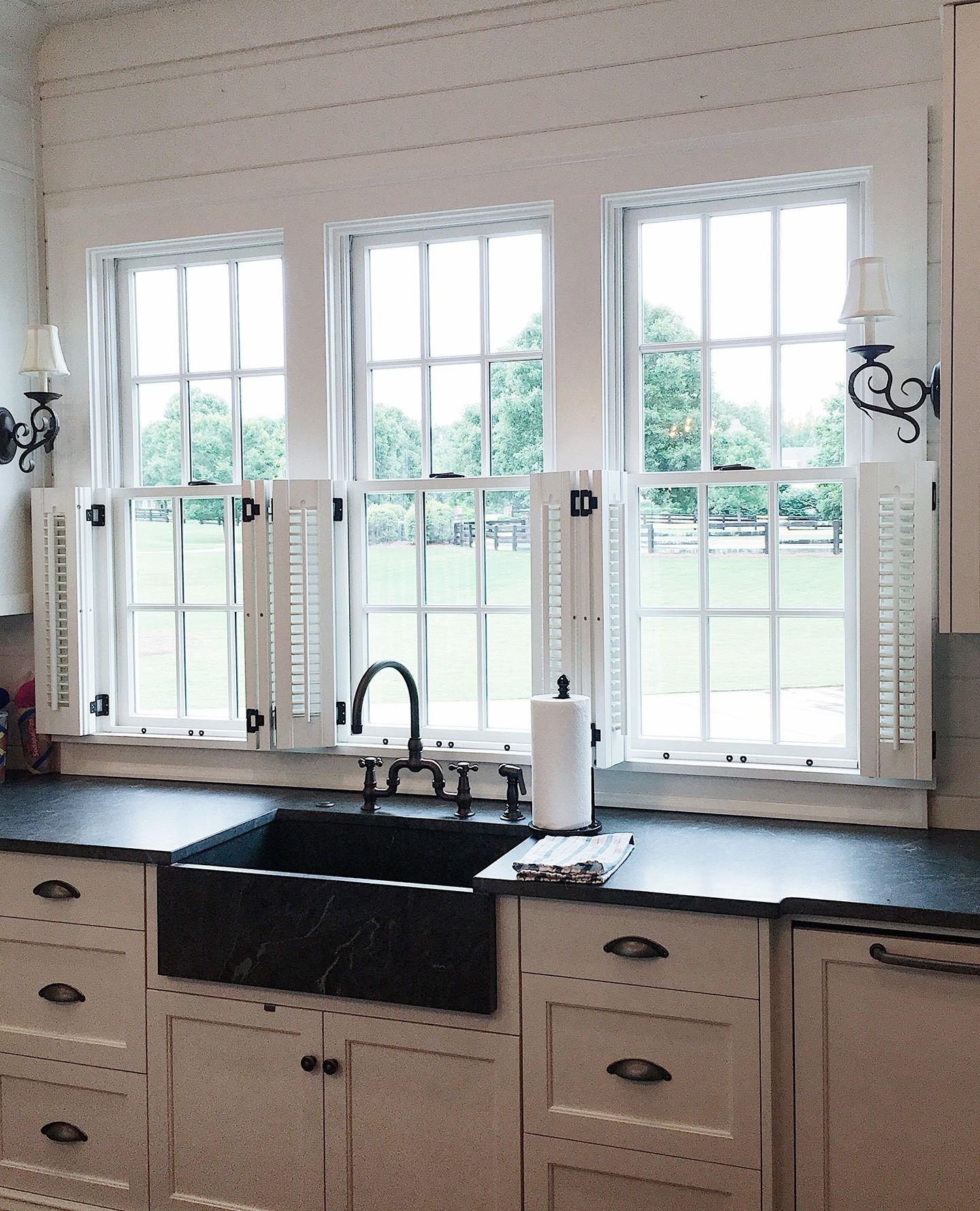 halfway white shutters in black and white kitchen with full height french style windows