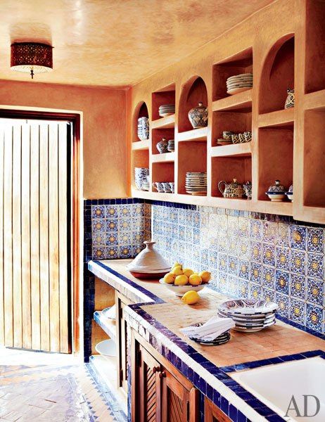 spanish rustic kitchen with blue spanish tile backsplash and burnt orange walls and ceiling