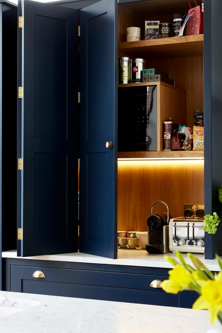 cabinetry with hidden compartment for appliances and product boxes, dark blue with internal lighting
