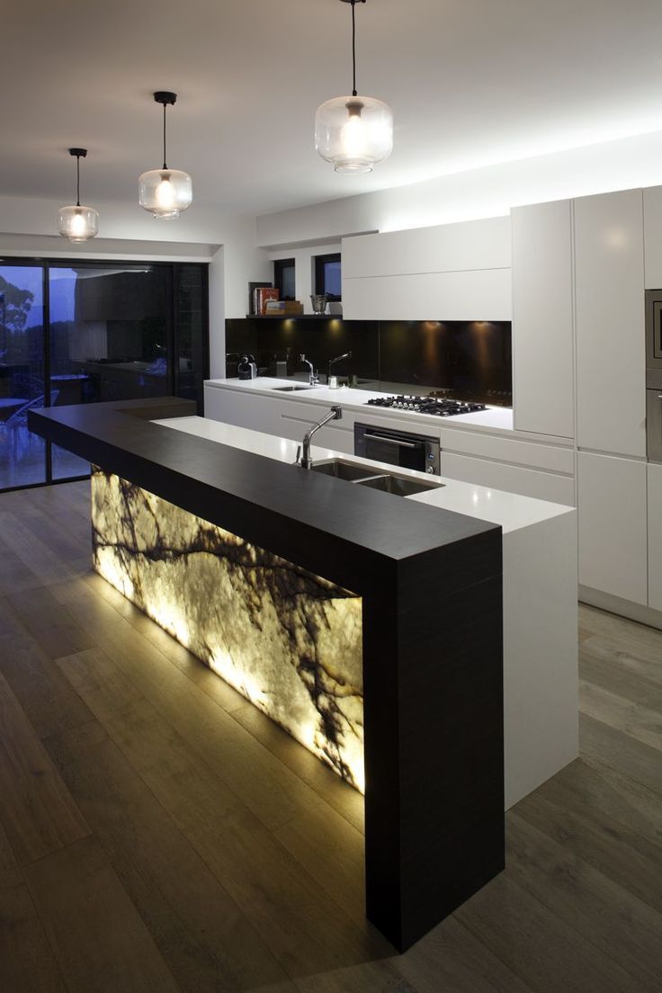 layered kitchen lighting example with light up marble island unit in modern black and white kitchen
